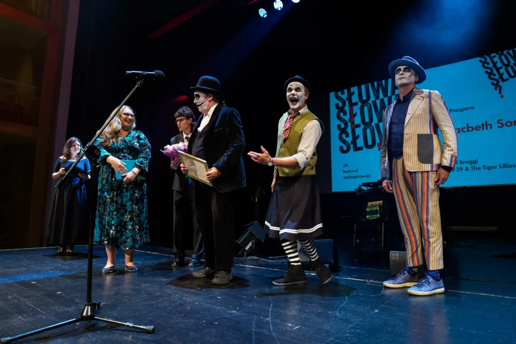 Prezes PTS, Anna Kowalcze-Pawlik wręcza nagrodę Księga Prospera zespołowi Tiger Lilies.